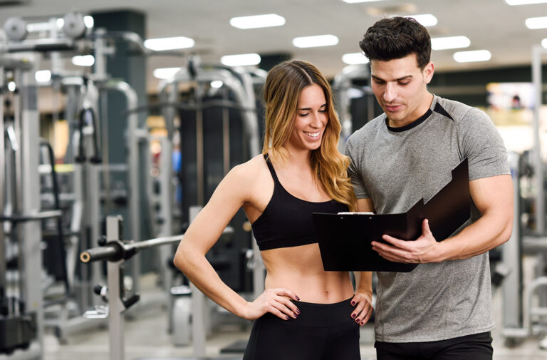 personal-trainer-and-client-looking-at-her-LYSKAQ7.jpg